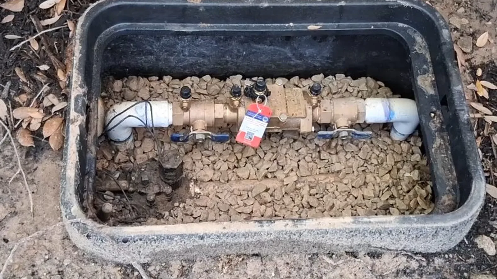 A technician testing a backflow preventer with pressure gauges during Backflow Testing & Prevention service in Alpharetta