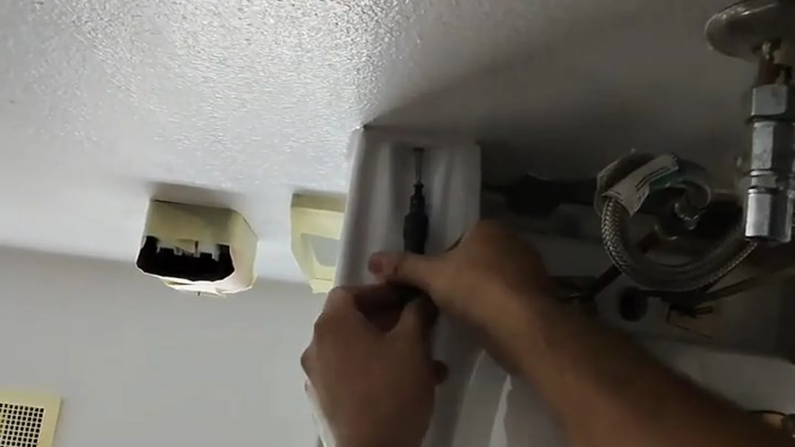 A P-trap being reassembled under a bathroom sink, representing Faucet & Sink Repair service