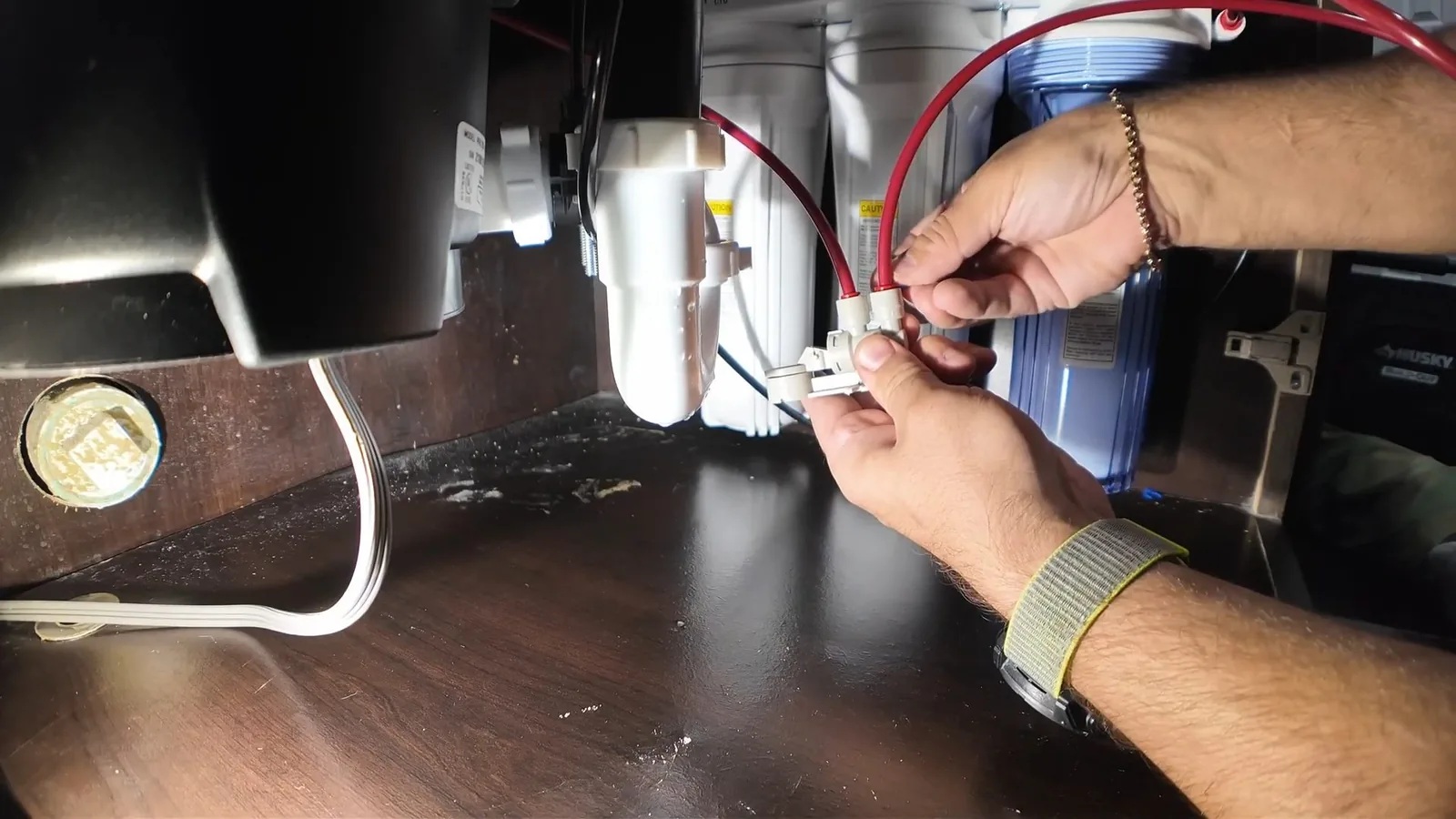 A technician assembling a multi-stage filtration housing, related to Water Filtration Installation questions homeowners ask