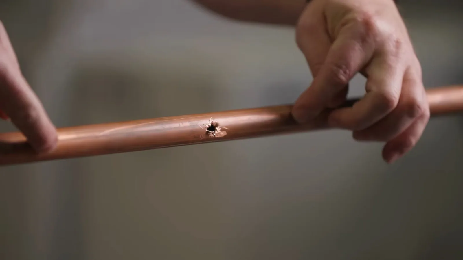 A burst copper pipe with a split seam from freezing, representing Burst Pipe Repair service
