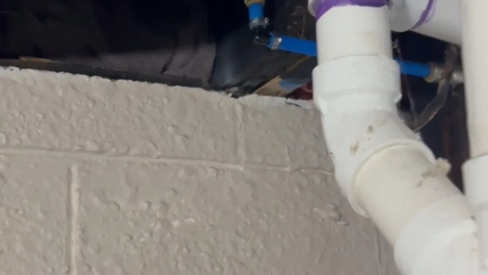 A garage wall opened to reach a burst supply line, related to Burst Pipe Repair questions homeowners ask