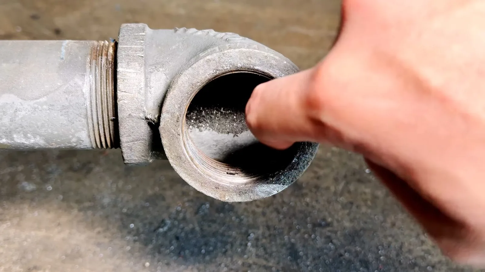 A failed section of cast iron pipe cut out of the ground, representing plumbing service in North Park