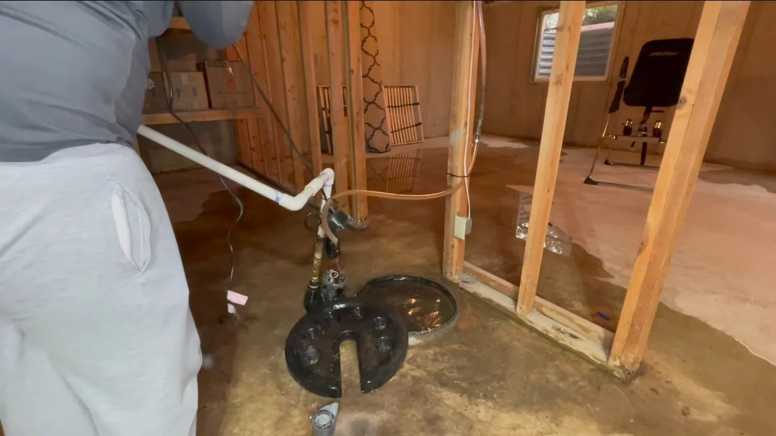 A sump pump being tested with water poured into the basin during a service visit in Old Milton