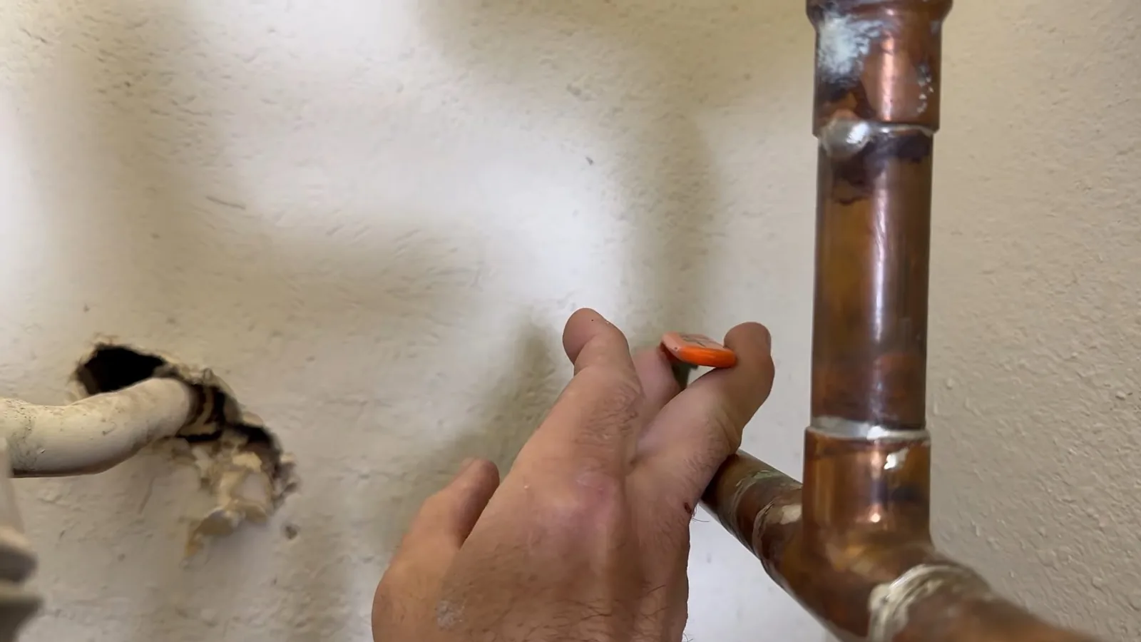 A leaking water heater inlet hose being replaced, representing plumbing service in Suwanee, GA